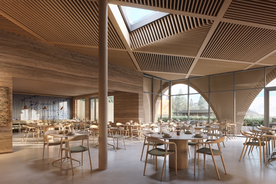 Interior of Ylja Restaurant at Laugaras Lagoon, featuring Icelandic design and panoramic views of the river and valley.