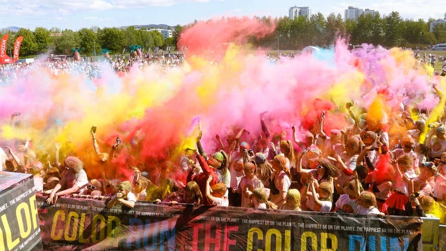 La foule lance de la poudre colorée pendant la Color Run, un événement haut en couleur qui figure parmi les principaux festivals d’Islande pour tous les âges.