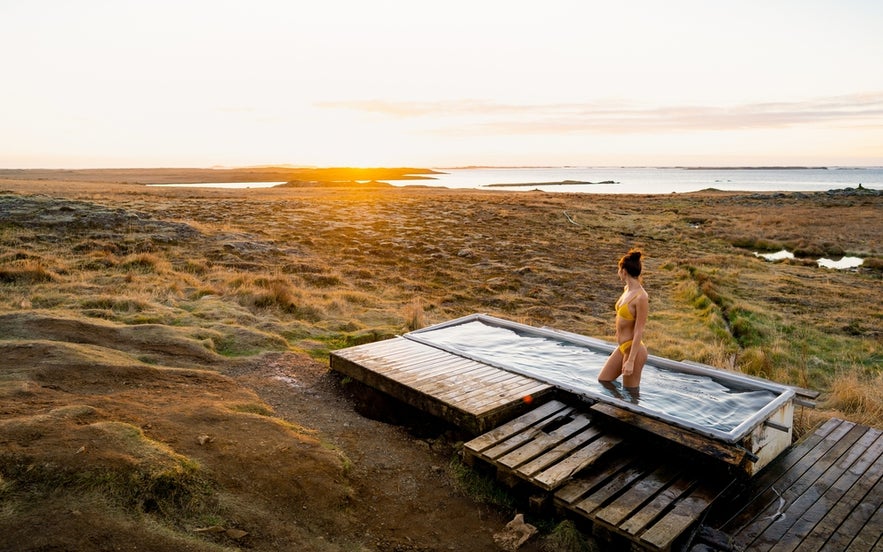  Djupavogskörin Hot Spring at sunset, surrounded by Icelandic nature and coastal views.