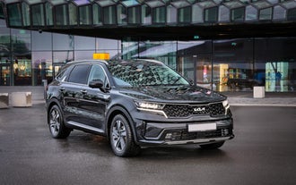 En stor sort Kia-bil parkeret uden for Keflavik Lufthavn.