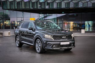 A large black Kia vehicle parked outside Keflavik International Airport.