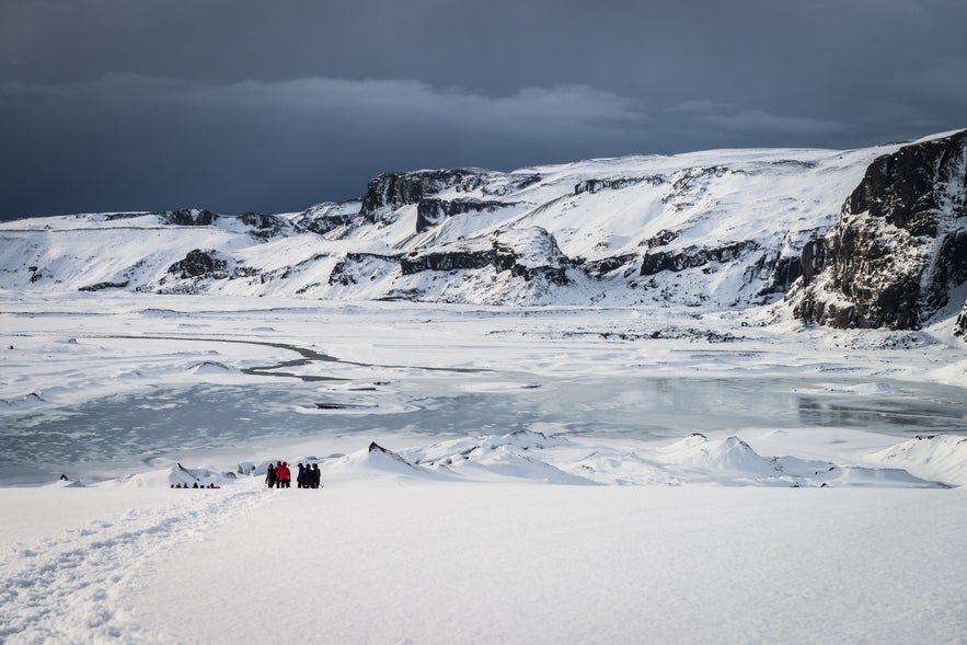 Snow-covered Eyjafjallajokull Glacier with hikers in view, one of the dramatic stages along the Volcanic Way.
