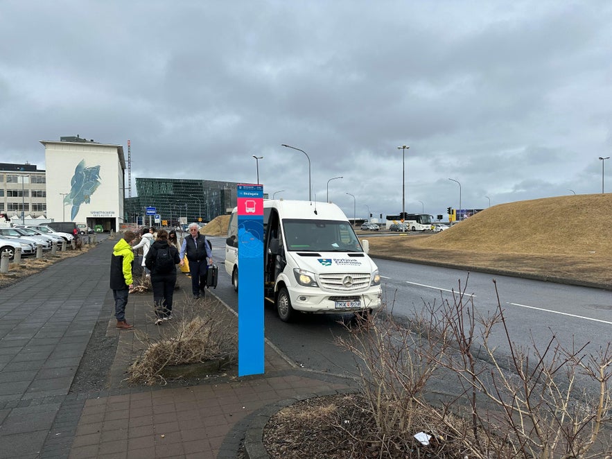 Retkeläisiä noutava minibussi Reykjavíkin pysäkillä 14.