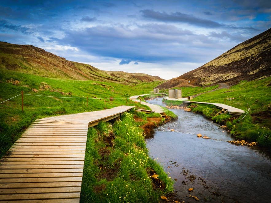 Hiking path and geothermal stream at Reykjadalur Valley, a popular hot spring area near Selfoss Town in South Iceland.
