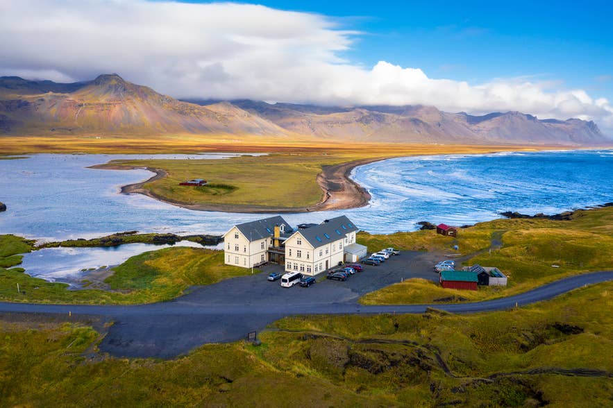 Budir Beach, Iceland, with mountains, ocean waves, and a dramatic coastal landscape.