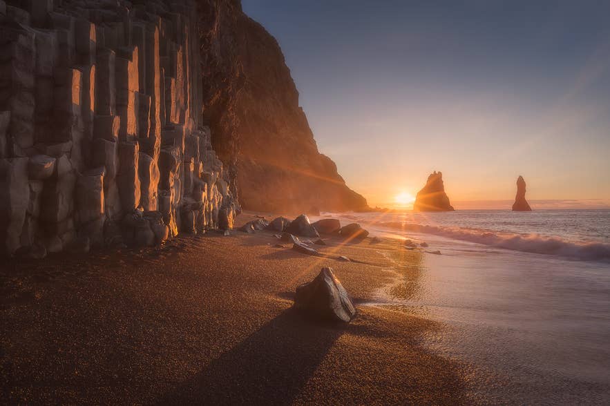 Low sun over the basalt columns at Reynisfjara, where reflected light raises UV exposure in Iceland.