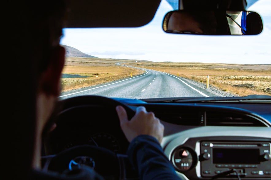 View from inside a rental car while driving in Iceland in August on a remote paved road through the Highlands.