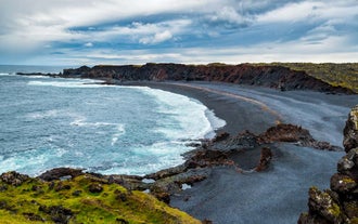 Waves crash along Djupalonssandur Beach, a black-pebble shoreline on Iceland’s west coast.
