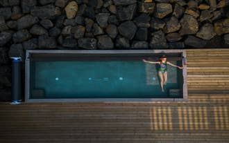 A woman enjoys a dip in one of the outdoor pools at Musteri Spa in Blabjorg Resort, East Iceland.