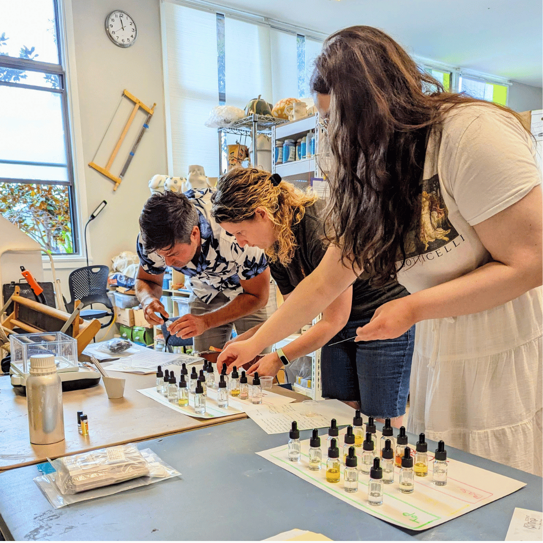 Participants blending scents at a hands-on perfume-making workshop in Reykjavik, using dropper bottles and natural oils.