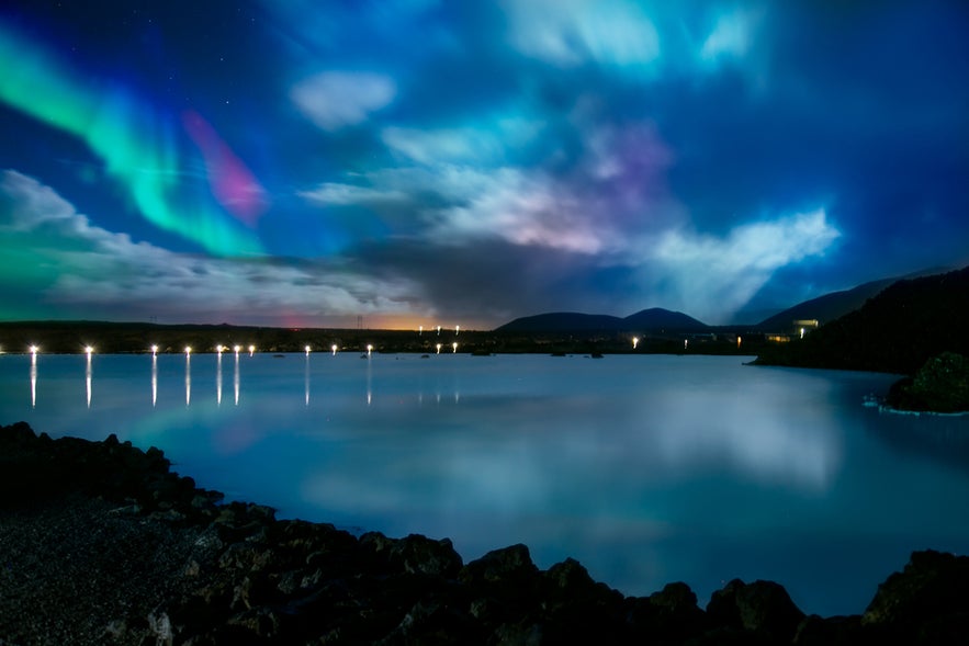 Northern lights over Blue Lagoon in Grindavik, Iceland, reflecting in the geothermal waters on a winter night.