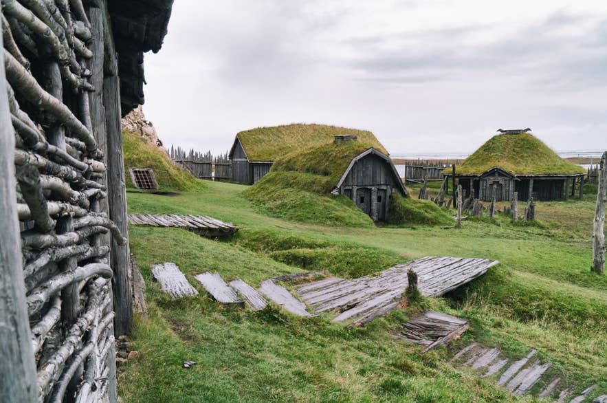 Nachgebaute Wikinger-Torfhäuser im Viking Village in Island, mit grasbedeckten Dächern und Holzstegen