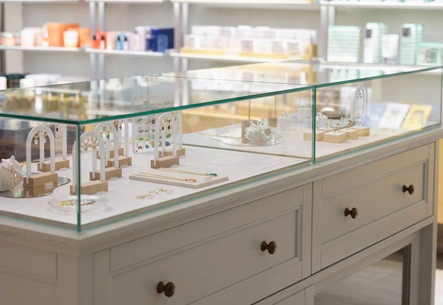 Glass display case with rings, earrings, and other jewelry sits on a white cabinet in Reykjavik’s Nomad gift store.