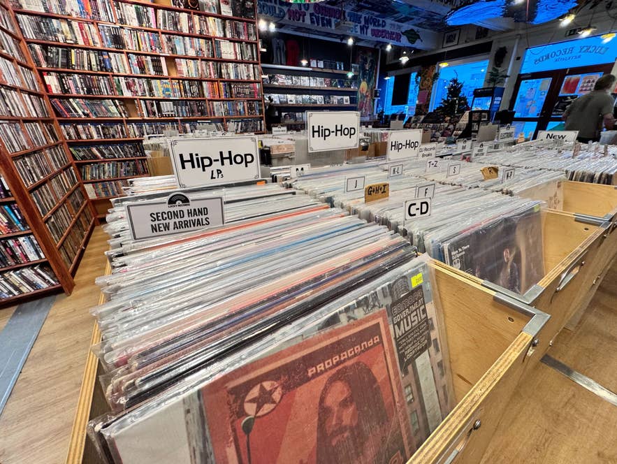 Reihen von Vinylplatten, sortiert nach Genre und Künstler, füllen Lucky Records in Reykjavík, mit sichtbaren Hip-Hop- und Second-Hand-Bereichen.