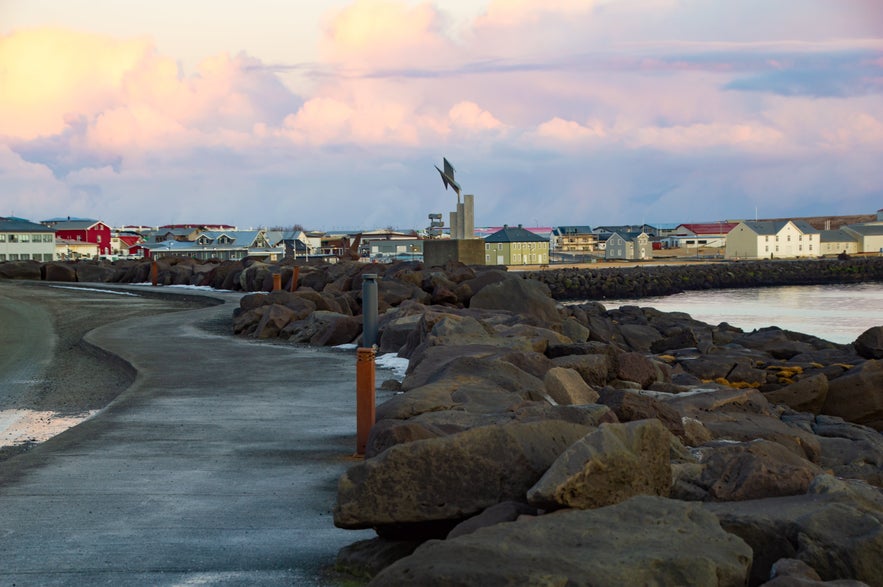 Seafront with meandering footpath and volcanic rock erosion control measures in Keflavik, Iceland.