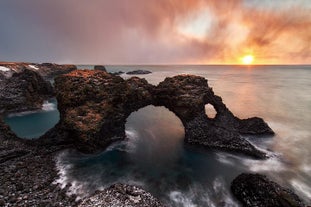 The black rock arch of Gatklettur near Arnarstapi looks breathtaking against the deep ocean.