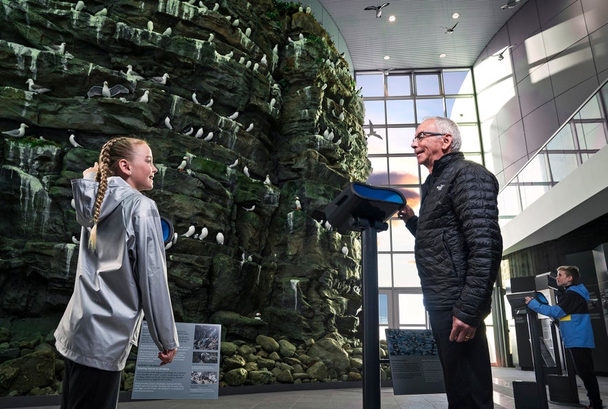 Menschen genießen die Rekonstruktion der Latrabjarg-Felsen im Perlan-Museum