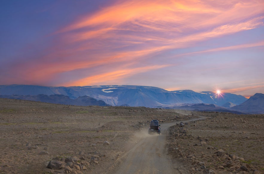 Jeep driving toward Langjokull Glacier at sunset on an Iceland highlands adventure tour.