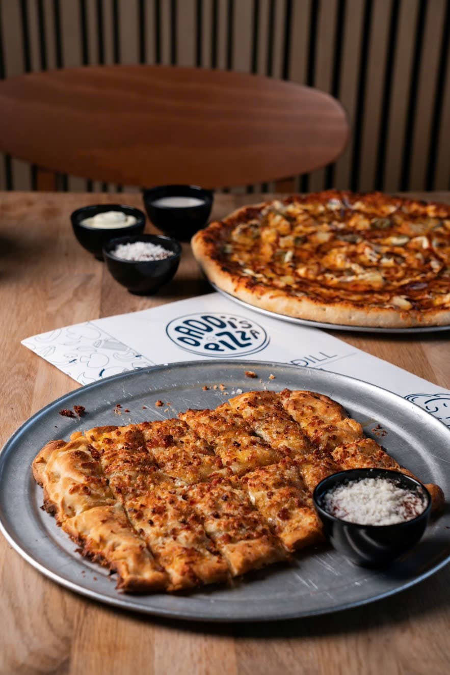 1 rectangle and round pizza on a table with Daddi's Pizza's menu between them