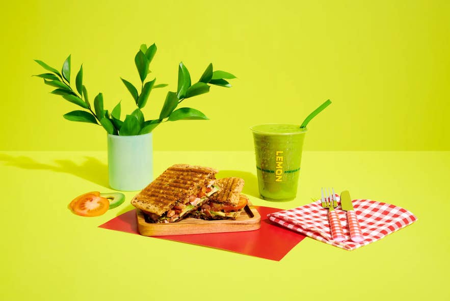 A grilled sandwich on a plate next to a green smoothie from Lemon, a sandwich shop in Iceland