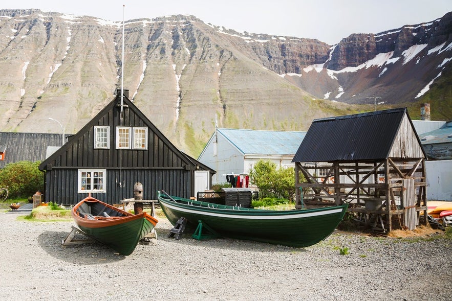Westfjords Heritage Museum with boats and mountain views, a must-see stop for things to do in Isafjordur, Iceland.