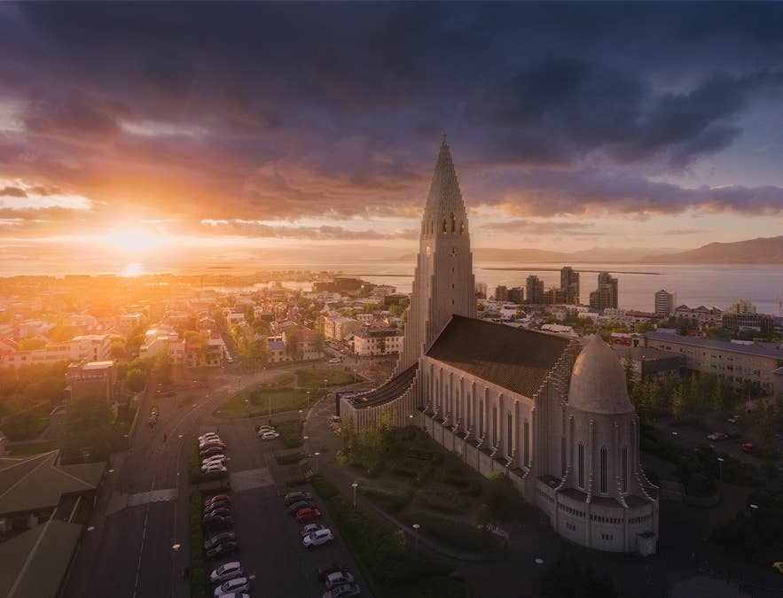 哈尔格林姆斯大教堂（Hallgrimskirkja）高耸于色彩缤纷的雷克雅未克屋顶之上，在夏日夕阳下熠熠生辉。