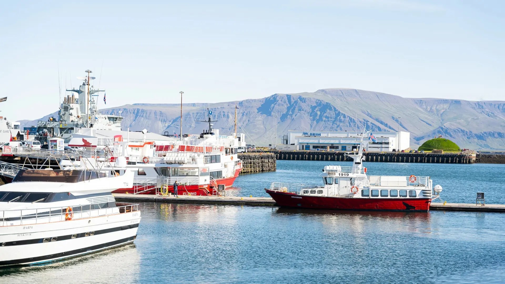 Reykjavik's Old Harbor with fishing boats and Mount Esja in the distance.