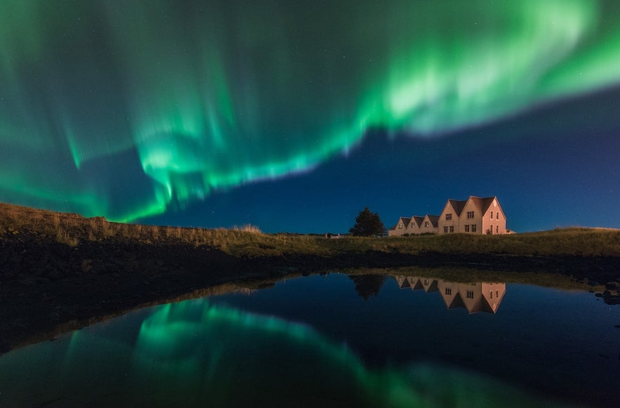 Aurore boréale dans le ciel au-dessus d'une maison à Straumur sur la péninsule de Reykjanes en Islande en hiver