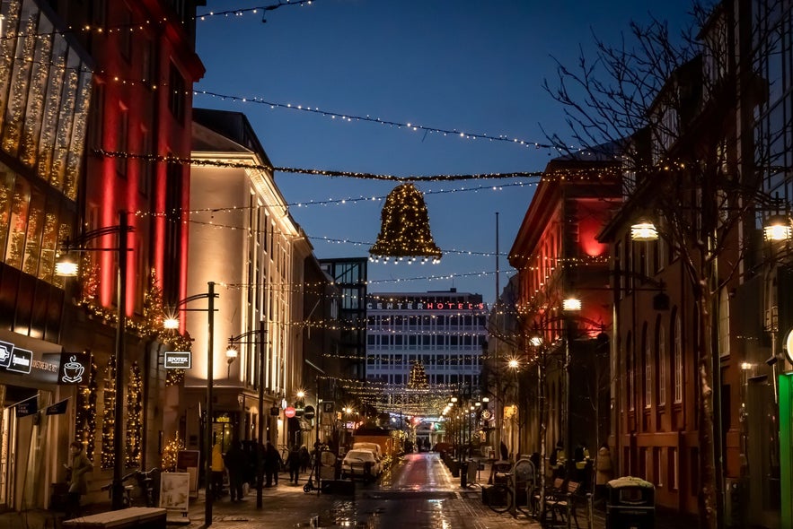 Laugavegur street in downtown Reykjavík beautifully decorated with Christmas lights and festive ornaments during the holiday season, offering a cozy atmosphere for bar hopping and nightlife in Iceland’s capital.