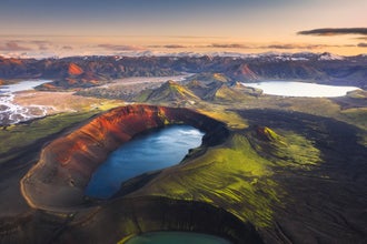 Hnausapollur crater lake in the Icelandic Highlands, with vivid blue water contrasting against red volcanic slopes in summer.