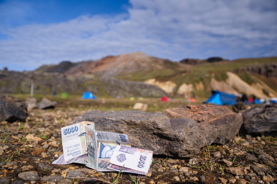 Money on stones in Landmannalaugar, South Iceland, representing finances and cost of living.