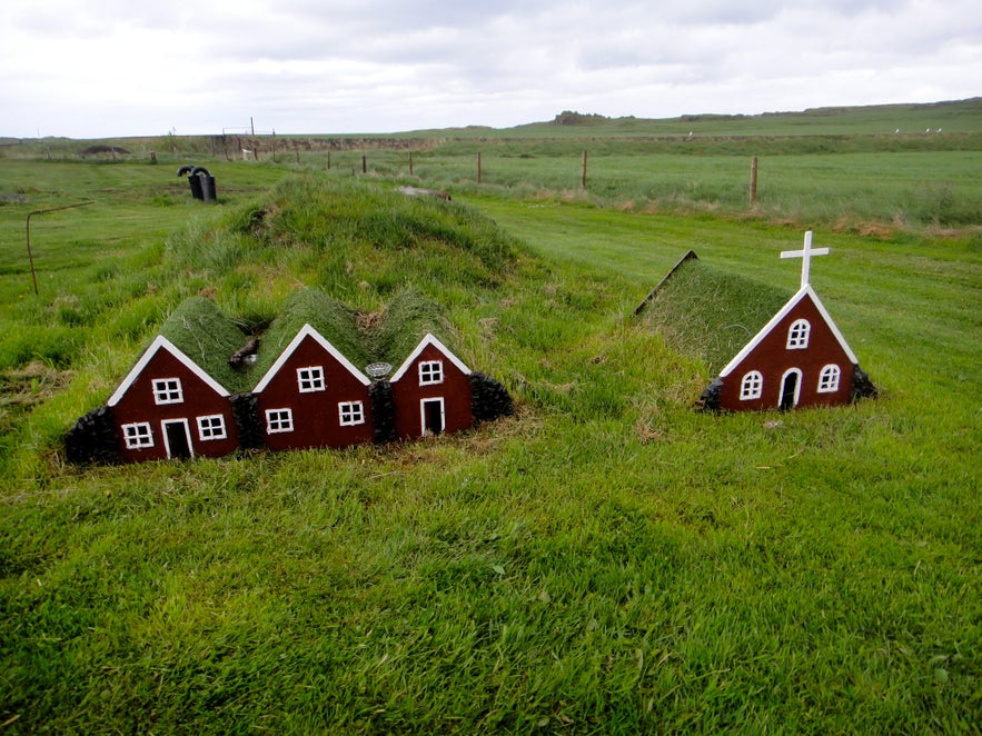 Alfhol, a row of small wooden elf houses in a yard in Akranes, illustrating Icelandic folklore.