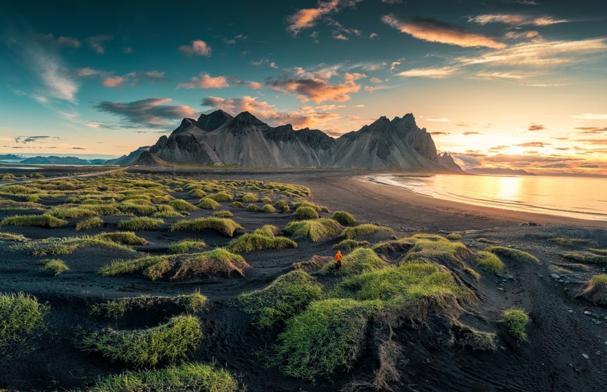 A view of Stokksnes Peninsula on Iceland’s southeast coast shows black sand dunes and the jagged Vestrahorn Mountain rising in the background.