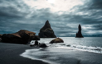 Reynisdrangar Sea Stacks rising from the Atlantic at Reynisfjara Beach.