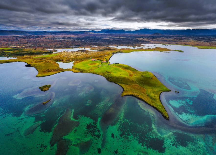 冰岛北部黑暗城堡附近米湖的航拍景色，湖水呈绿松石色，点缀着火山岛屿。
