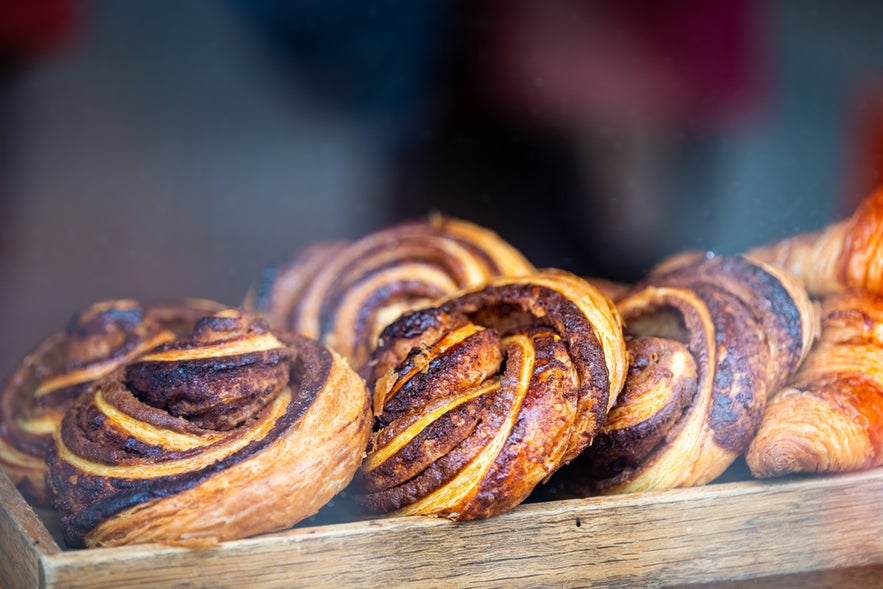 Freshly baked snudur pastries on display in a wooden tray at a bakery in Reykjavik.