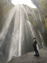 Senti la nebbia sul viso mentre ti avvicini alle cascate durante la gita di un giorno a Vik.