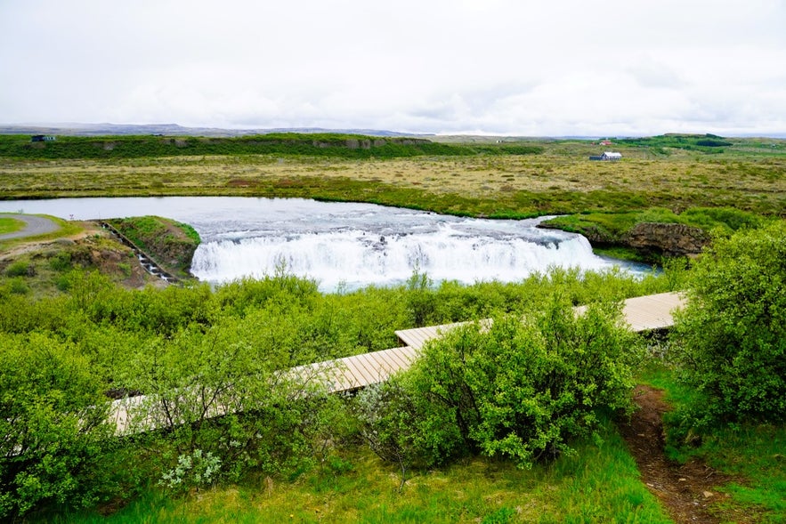 Faxafoss Waterfall in Iceland with wooden walking paths, green landscapes, and views near Skalholt and Thingvellir.