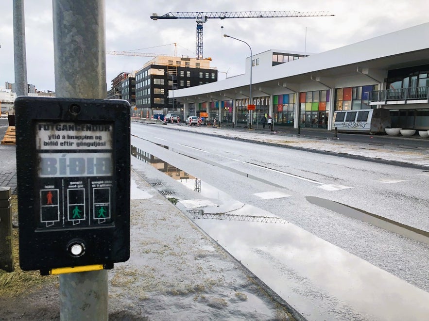Kolaportid Flea Market in Reykjavik, Iceland on a rainy day with street reflections and nearby modern buildings.