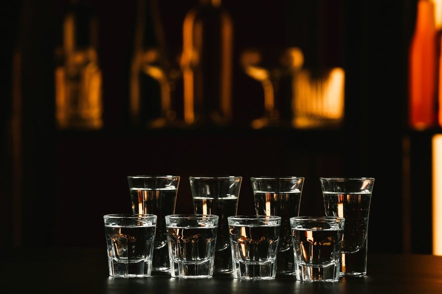 Icelandic liquor and spirits in shot glasses at a Reykjavik bar, featuring local drinks from Akureyri, Seydisfjordur, and Vik.