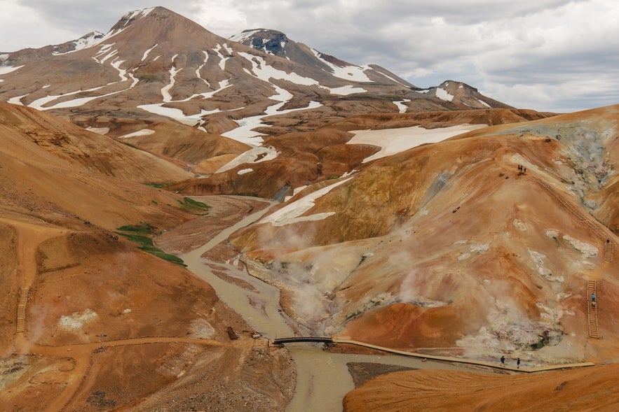 Kerlingarfjoll Mountains with colorful, steaming hills, snow-capped peaks, and hiking paths through the volcanic terrain.