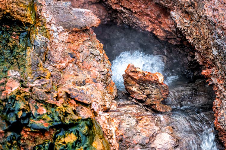 Hot water rushes out of a fissure in the rocky walls of Deildartunguhver Hot Spring.