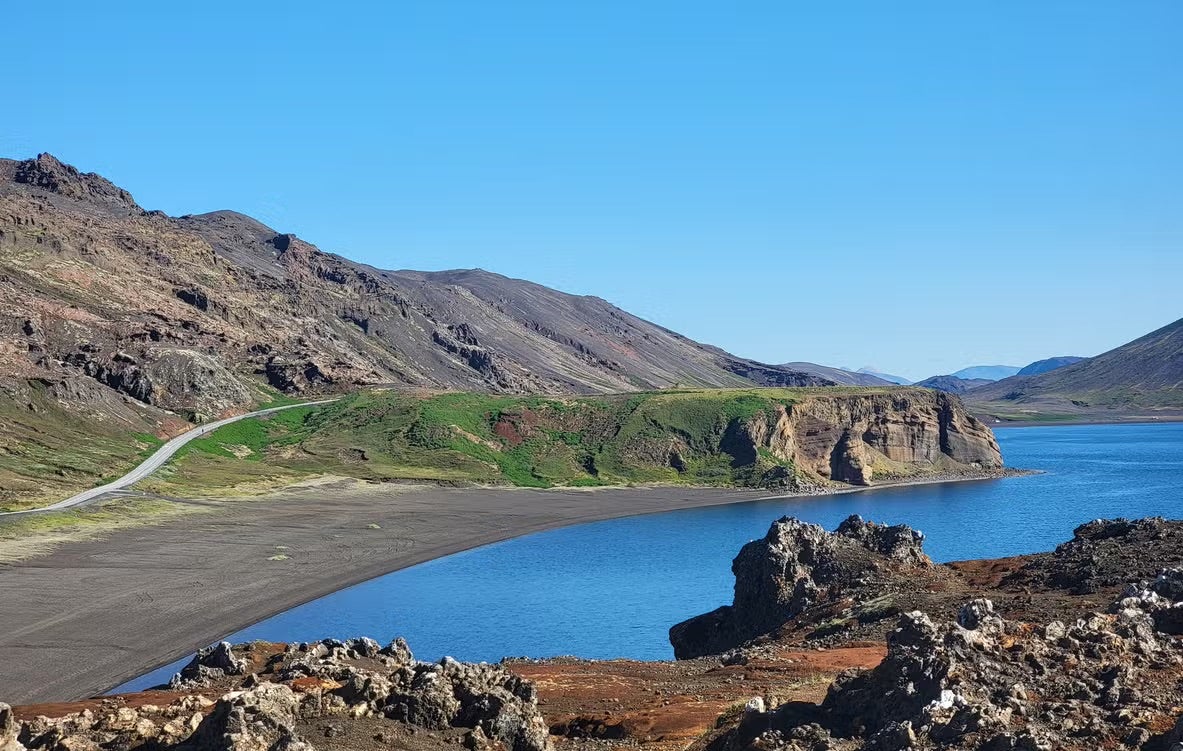 A zoomed-out view of Lake Kleifarvatn with volcanic mountains near Harfnarfjordur in the distance.