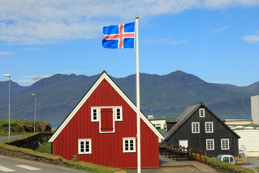 Langabúð，位于都皮沃古尔的历史悠久的红色木屋，前方飘扬着冰岛国旗。