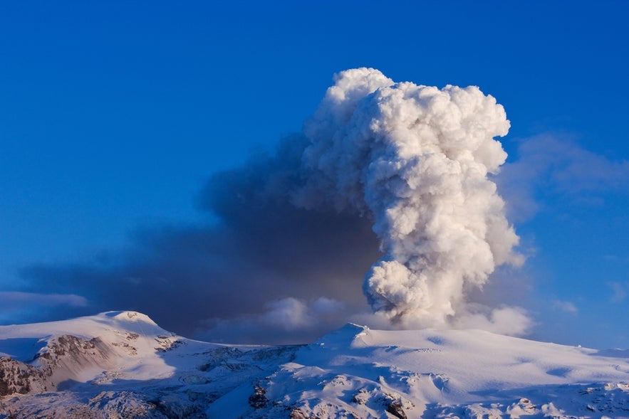 Volcanic eruption at Eyjafjallajökull Glacier in South Iceland, with ash against the icy landscape.