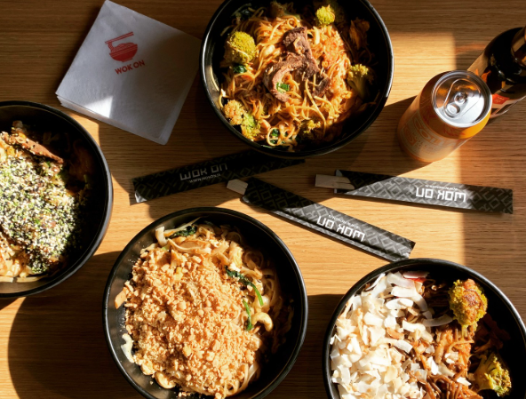 Noodle bowls served at Wok in Vik restaurant in Vík, Iceland, with drinks and chopsticks on the table.