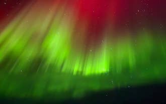 Ribbons fo green and red dance in a cool display of the northern lights near Seljalandsfoss Sky Reatreat in Hvolsvollur.