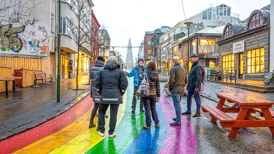 Matkailijoita tutustumassa sateenkaarikatuun Reykjavikin keskustassa.