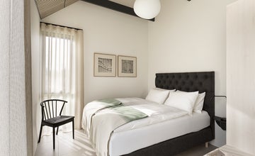 ห้องนอนดีลักซ์ที่ Heidin พร้อมเตียงควีนไซส์ เพดานสูง และหน้าต่างบานใหญ่พร้อมผ้าม่านโปร่ง