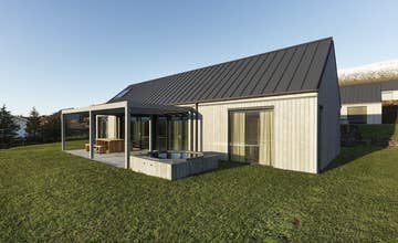 Heidin外观,位于Eyjafjardarsveit山谷的一栋现代乡村住宅,带露台和大面积落地窗。